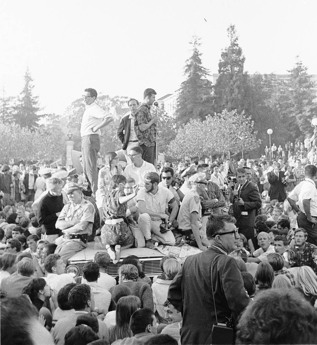 Steven Marcus, Art Goldberg, Brad Cleaveland and Nicholas Zvegintzov on car surrounded by students 10-1-1964